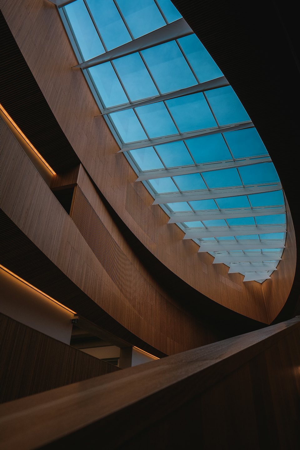 Pareti interne e soffitto curvi in legno con texture lineari.