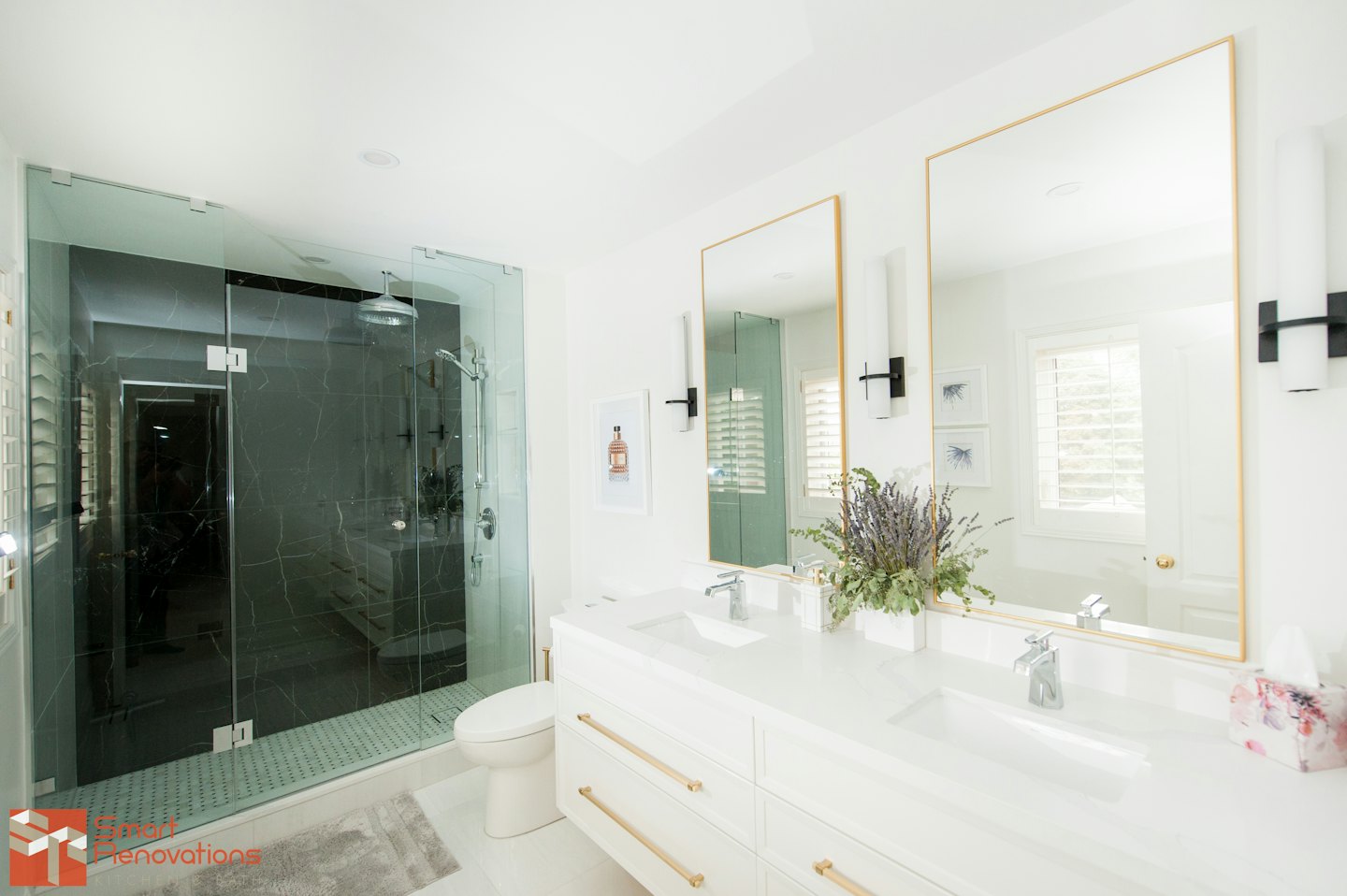 Bagno moderno con doccia in vetro e doppio lavabo.