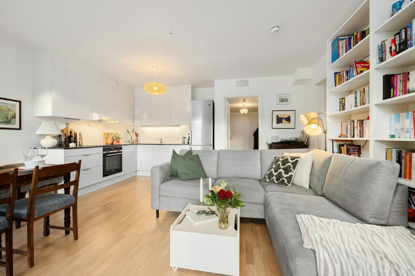 Appartamento open space con divano grigio e cucina moderna.