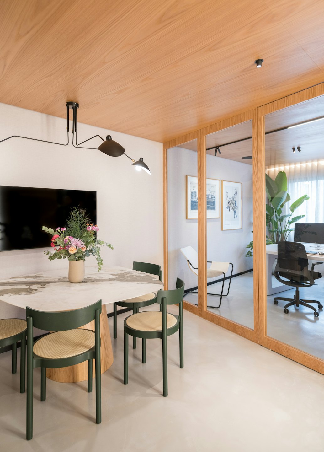 Moderna sala riunioni con tavolo in marmo e sedie verde scuro.